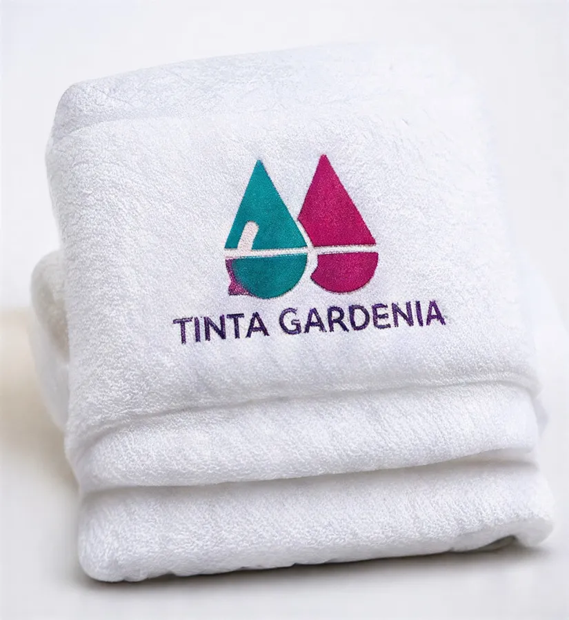 Toallas blancas dobladas con el logo bordado